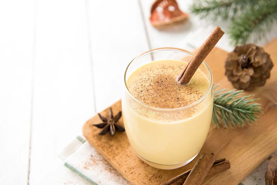 Glass of egg nog with cinnamon stick